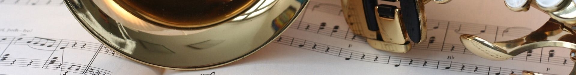 close up image of a trumpet laid over sheet music